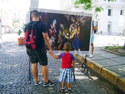 Un padre y su hijo disfrutan reproducciones de famosas pinturas