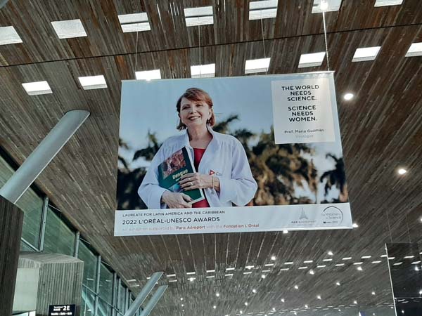 Póster de la doctora María Guadalupe Guzmán Tirado en el Aeropuerto Internacional de París. Foto. / salud.msp.gob.cu
