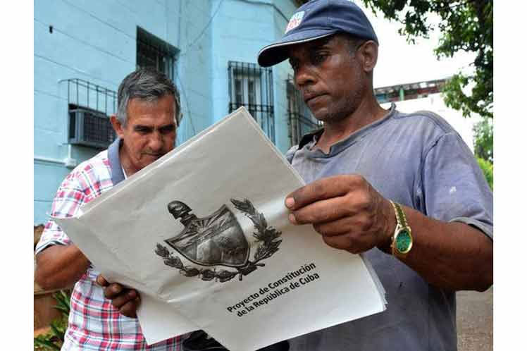 Cubanos leyendo documento de nueva Constitución