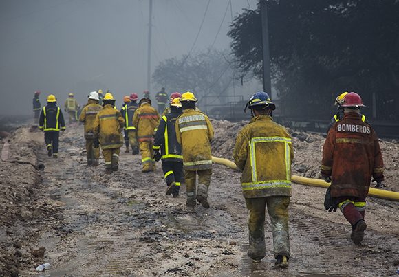 Caminan en fila, uniformados de las botas al casco, hacia el incendio. Foto: Irene Pérez/ Cubadebate.