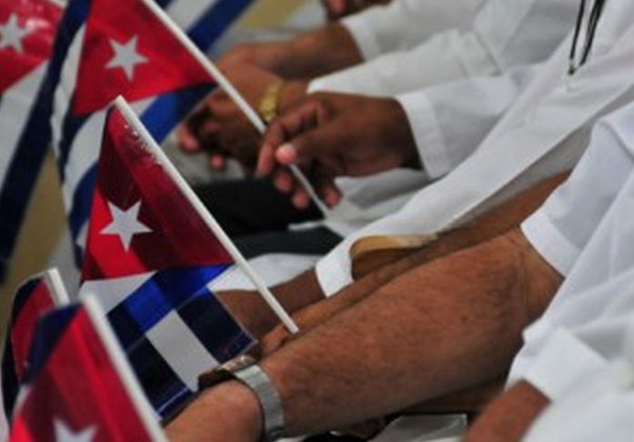 Médicos cubanos sostienen banderas de Cuba