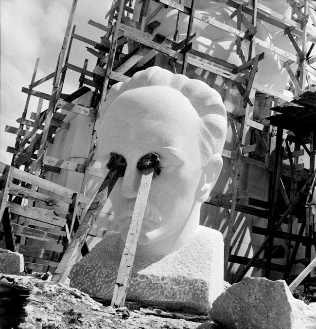 fotografía de Ernesto Fernández sobre la escultura de Martí con los ojos cubiertos por dos vigas.